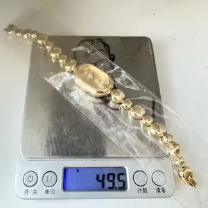 Detail view of a vintage style gold oval quartz watch weighing 49.5g on a scale