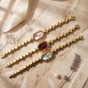 Detailed shot of three vintage oval quartz watches with golden bean chain bracelets.