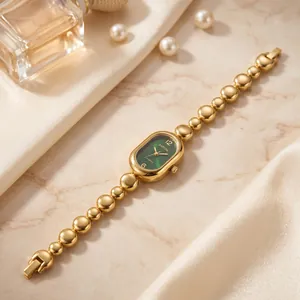 Detailed view of an elegant golden bead chain watch with a green oval dial and quartz