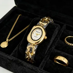 Gros plan d'une montre à quartz dorée pour femme avec cadran ovale et bracelet chaîne