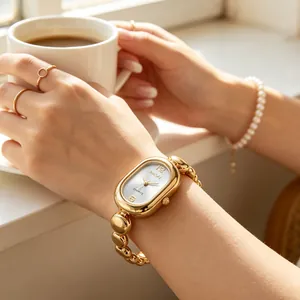 Close-up of a vintage-style gold bean chain oval quartz watch on a lady's wrist