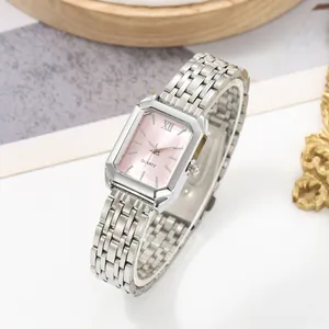 Close-up detail of luxury rectangular women's watch with pink dial and silver steel strap