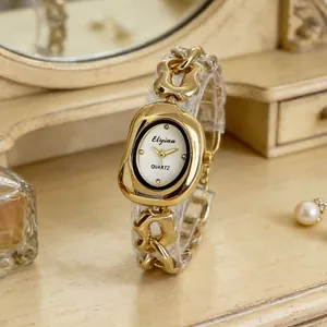 Gros plan d'une montre à quartz pour femme avec bracelet chaîne dorée et cadran ovale.