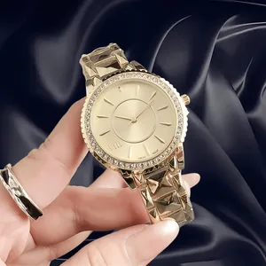 Close-up of elegant gold women's watch featuring crystal bezel and faceted geometric strap