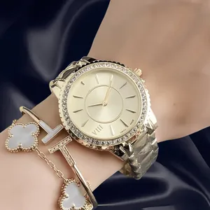 Close-up of elegant luxury gold watch and bracelets set featuring clover and T designs.