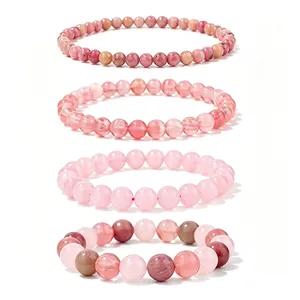 Detail view showing four stacked pink crystal and natural stone beaded bracelets