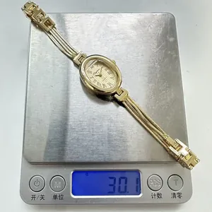 Messung der goldenen ovalen Quarzuhr auf einer Digitalwaage mit einem Gewicht von 30,1g