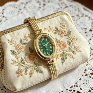 Elegante ovale goldene Quarzuhr mit grünem Zifferblatt und besticktem Beuteldetail