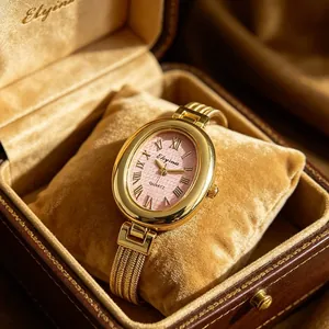 Nahaufnahme einer eleganten ovalen goldene Damenuhr mit rosa Zifferblatt in einer Box