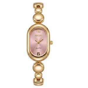 Detail view of a luxury golden bean chain ladies watch with elegant pink oval dial