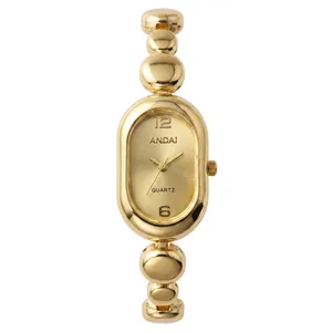 Close-up of elegant gold oval watch with unique bean-shaped link bracelet