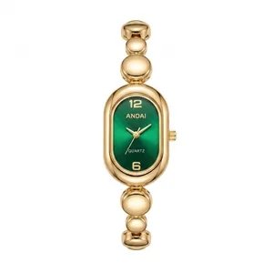 Detailed macro view of a gold bead link watch with an emerald green oval dial design