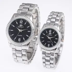 Détail de montres à quartz pour couple en argent avec cadran noir et lunette cannelée