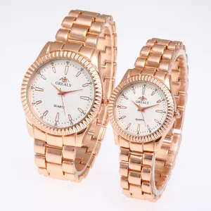 Primo piano di eleganti orologi al quarzo per coppia in oro rosa con cinturini in acciaio.