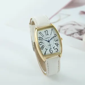 Elegant close-up of XAPWV tonneau-shaped watch featuring a white leather strap and gold case