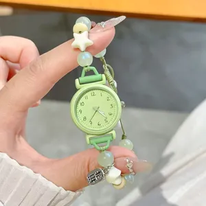 Close-up of cute mint green beaded bracelet watch with star charms for students