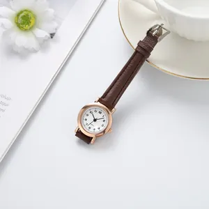 Gros plan d'une montre femme minimaliste avec bracelet en cuir marron et boîtier en or rose