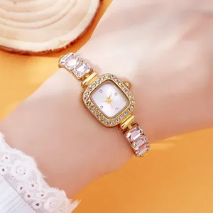 Elegant gold square ladies watch with rhinestone bezel and crystal bracelet on wrist