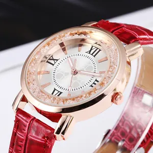 Detailed close-up of rose gold watch with crystal bezel and red leather strap