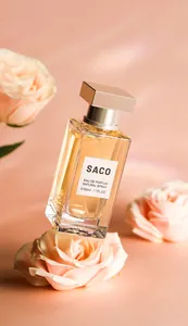 Close-up shot of SACO Eau de Parfum glass bottle elegantly placed among blooming pink roses