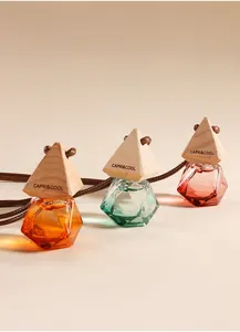 Set van drie diamantvormige autoparfumflesjes met houten doppen.