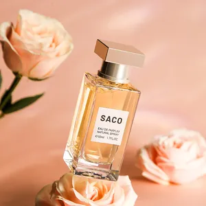Elegant 50ml SACO Eau de Parfum natural spray bottle surrounded by delicate pink roses.