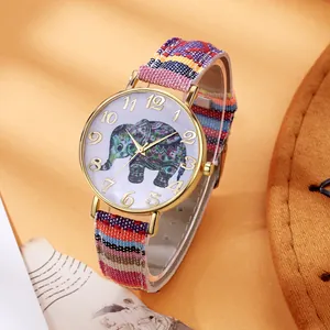 Macro view of bohemian watch dial with colorful elephant and ethnic canvas strap detail