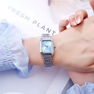 Elegante silberne Damenuhr mit blauem Zifferblatt am Handgelenk mit Gliederarmband.