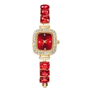 Elegant gold women's watch featuring a red square dial and matching gemstone link strap