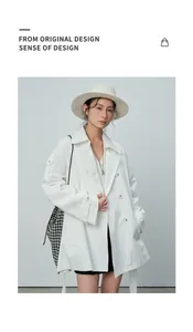Mannequin asiatique portant un trench-coat blanc à double boutonnage et un chapeau fedora