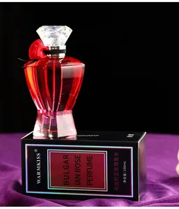 Detailansicht der roten Glasparfümflasche mit Rosenakzent auf schwarzer Box