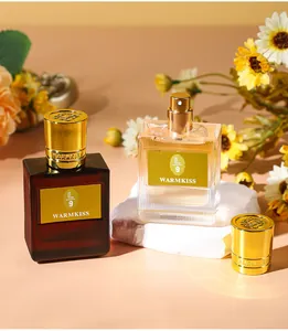 Close-up of Warmkiss perfume bottles featuring golden caps and floral decorations