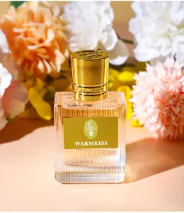 Elegant WARMKISS perfume bottle with gold cap and floral background