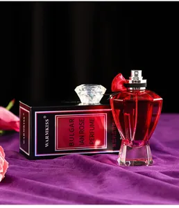Nahaufnahme der roten WARMKISS Parfümflasche in Diamantform mit eleganter Box.