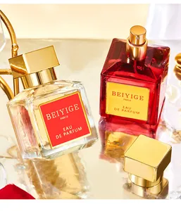 Primo piano di eleganti boccette di profumo rosse e oro con una fragranza floreale