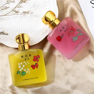 Vista dettagliata di flaconi di profumo da 35 ml all'osmanto e rosa su seta lussuosa.