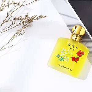 Primo piano della boccetta di profumo in vetro satinato giallo con tappo dorato e fiori