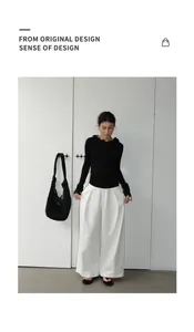 Elegant black ruffle neck top paired with minimalist white wide-leg denim trousers