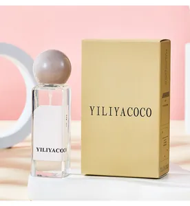 Vista dettagliata dell'elegante flacone di profumo e della sua confezione dorata.