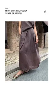 Detail of brown irregular pleated maxi skirt with textured fabric in a street setting