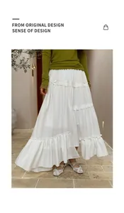 Detailed view of white tiered maxi skirt with irregular hem and ruffled layers