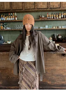 Élégant trench-coat marron à double boutonnage pour femme dans un café vintage chic