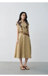Elegant sleeveless beige A-line dress with lapel collar and silk scarf detail on a model