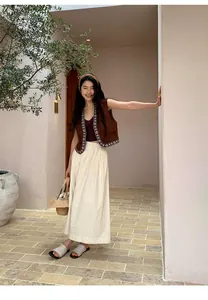 Asiatisches Model trägt eine braune Weste im Ethno-Stil in einem mediterranen Innenhof