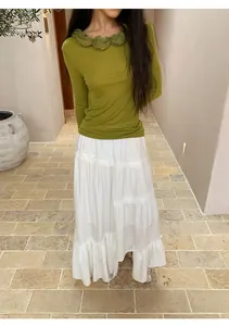 Full view of elegant white tiered irregular long skirt with a green long-sleeved ruffle top.