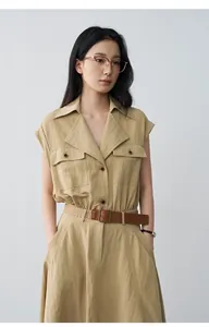 Detail view of a khaki sleeveless lapel dress with a brown belt and buttons.