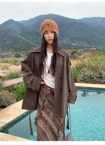 Élégant trench-coat marron à double boutonnage mi-long pour femme en extérieur naturel