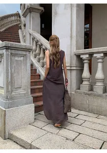 Detailed back view of a brown pleated maxi skirt set worn by a model on stone staircase