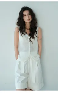 Elegant detail view of a white mesh patchwork knit vest worn by a stylish Asian model