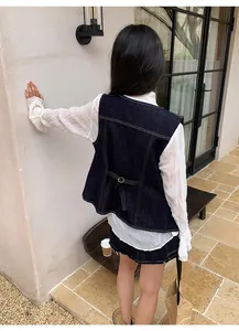 Vue arrière d'un gilet en jean bleu foncé vintage avec surpiqûres et boucle en métal